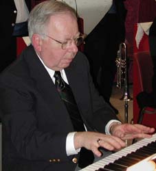 Norm Herzog plays an animated solo, both hands above the keys.