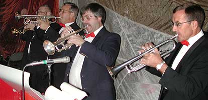 The section members play trumpets wearing red bow ties.