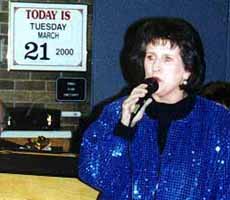 Karen sings in front of the date sign: Tuesday, March 21, 2000. Bigger picture is 52K.