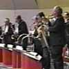 The sax section stands at the conclusion of a song, in the Roseville Central Park band shell.