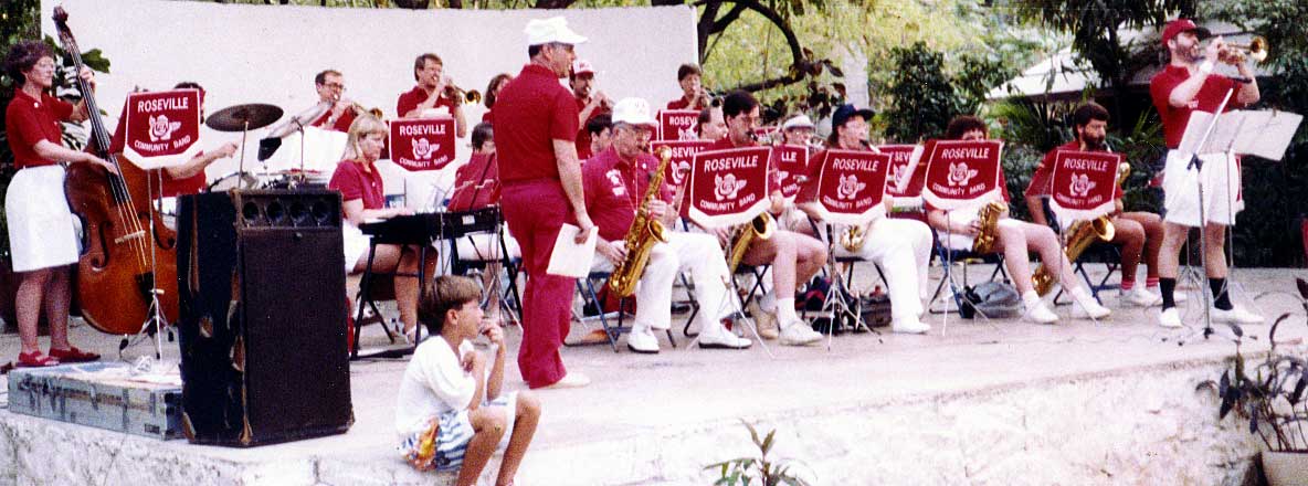 The band plays on a stone and adobe stage in a park.