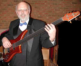 Mike holds his Alembic fretless bass in playing position.
