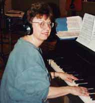 Ann wears headphones as she plays Studio M's grand piano.