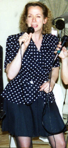 Cindy sings straight ahead in polka dots and black.