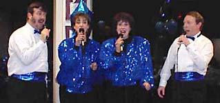 Dressed in blue sparkles and white, Glen, Diane, Karen, and Kirk sing a lively song.