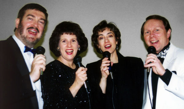 The quartet sings at the camera.