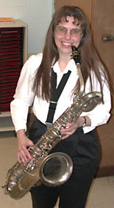 Deb smiles for the camera, holding her silver Conn baritone sax.