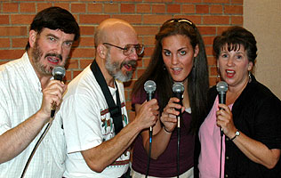 Quartet members pose with mics in hand.