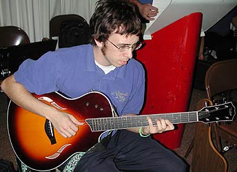 Cory plays his Taylor guitar.